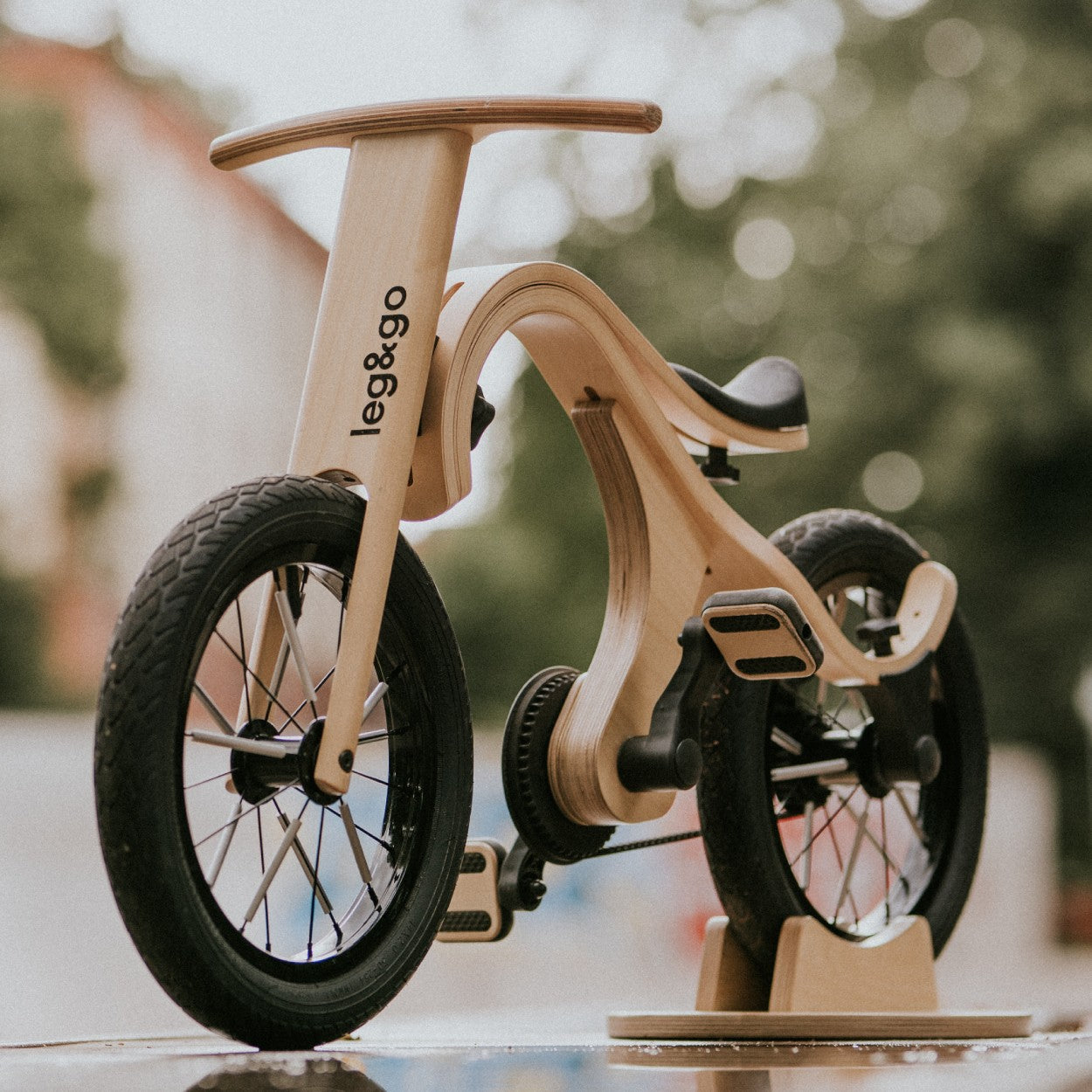 Close-up of leg&go pedal bike showing wooden frame curved design