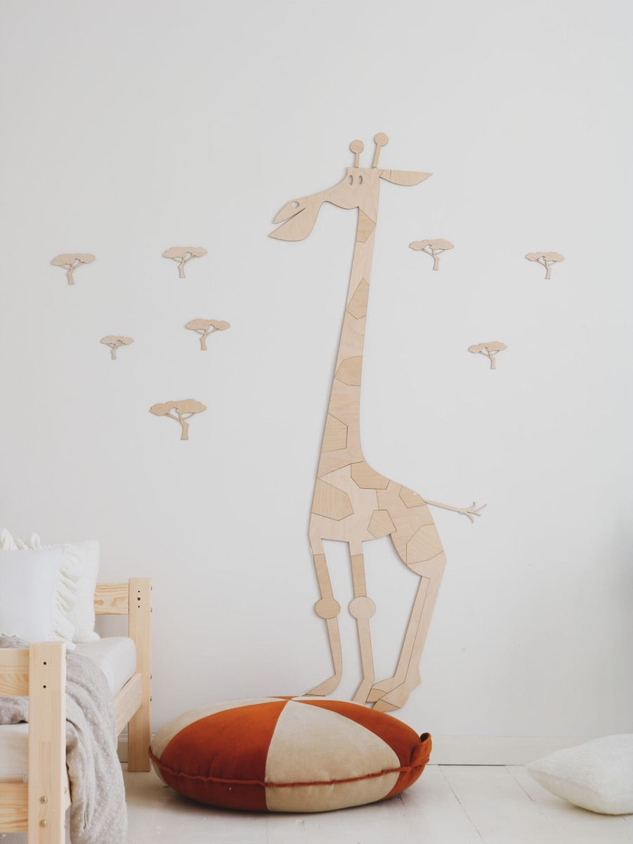 Wooden giraffe wall sticker above bed with acacia tree details and coordinating wall decals in playroom