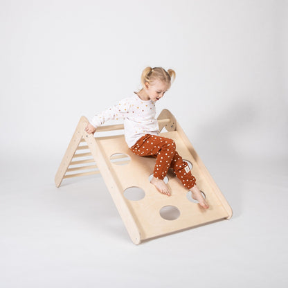 Young child climbing the ramp side of folding climbing triangle