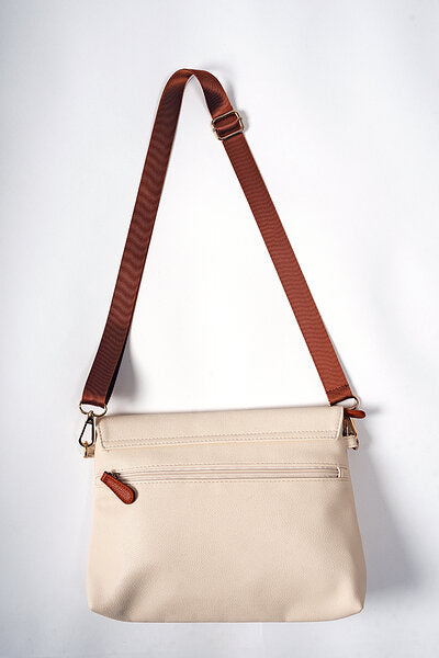 Cappuccino handbag showing front zippered pockets and brown leather strap detail