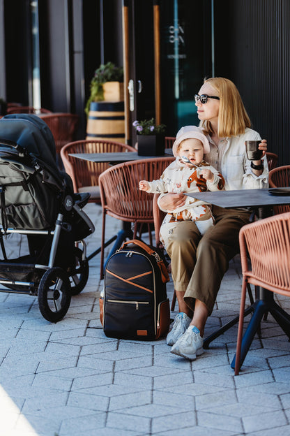 Diaper backpack attached to stroller handle in black coffee vegan leather