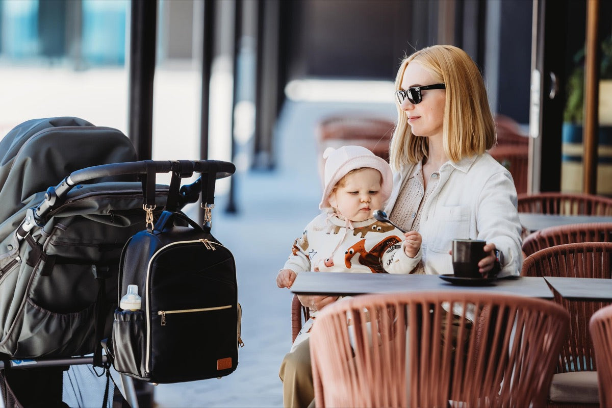 Mother at cafe with espresso backpack in use while holding child