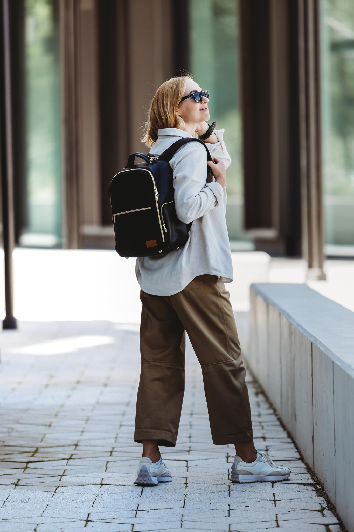 Woman wearing black Ally Scandic diaper backpack on city street