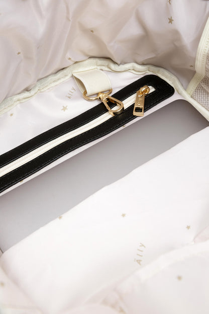Black shoulder straps and gold hardware in luxury packaging detail