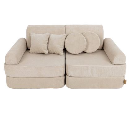 Modular kids sofa with square cushions and round pillows arranged on backrest in ecru