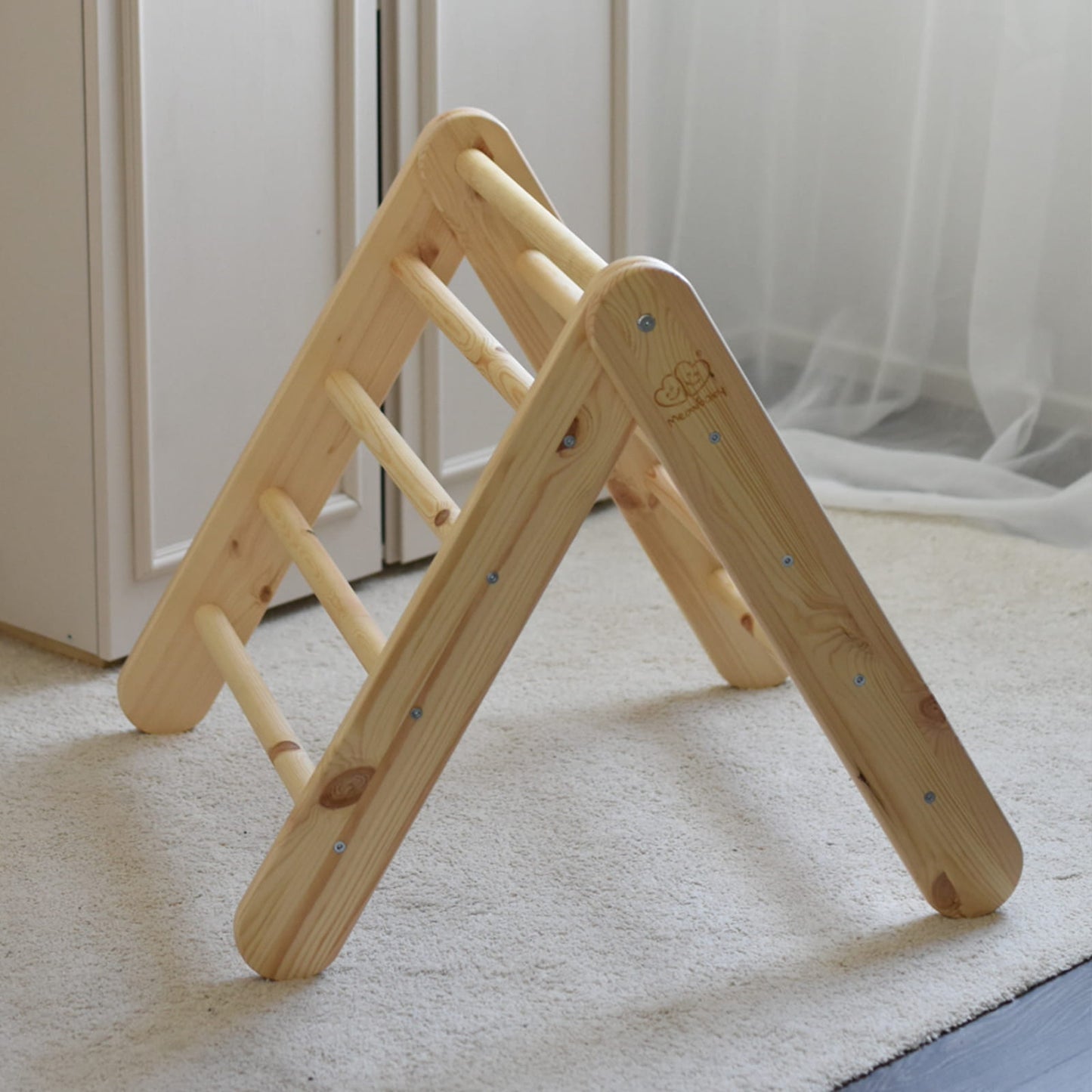 Natural wood climbing ladder alone in room with pink fabric tent attached
