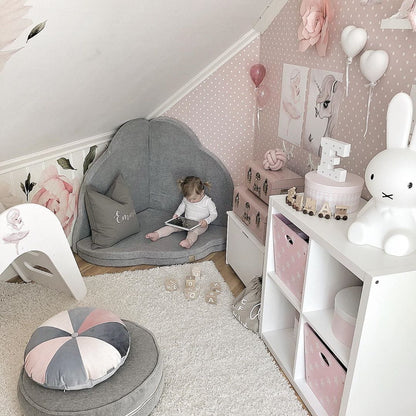 Baby playing inside light grey cloud mat in styled nursery room with accessories
