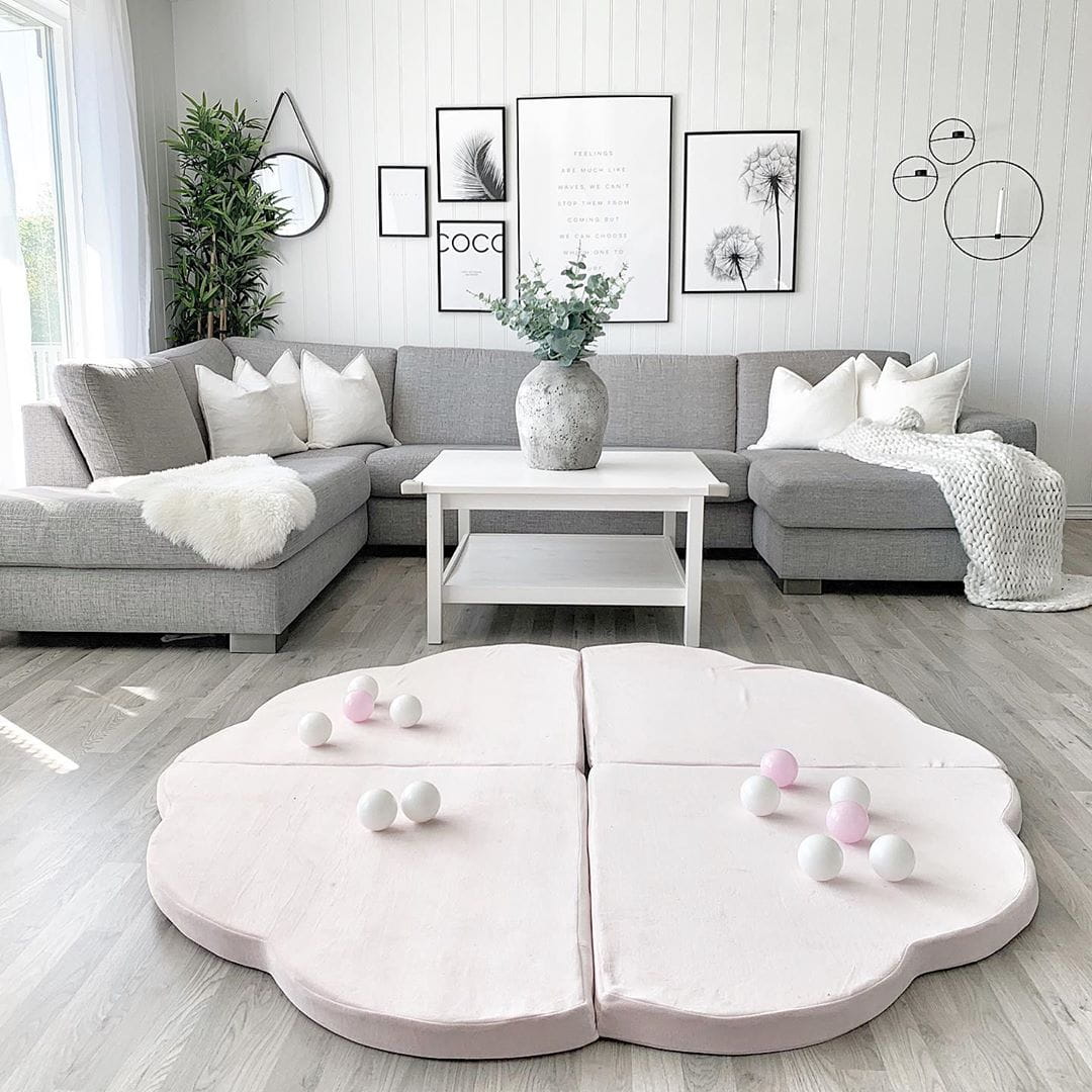 Pink cloud play mat styled in modern living room with gray sofa