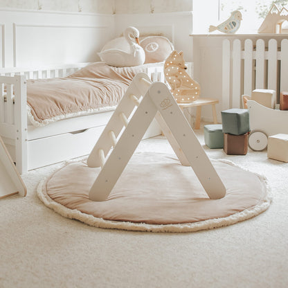 White climbing wall and natural wood slide in soft gender-neutral bedroom