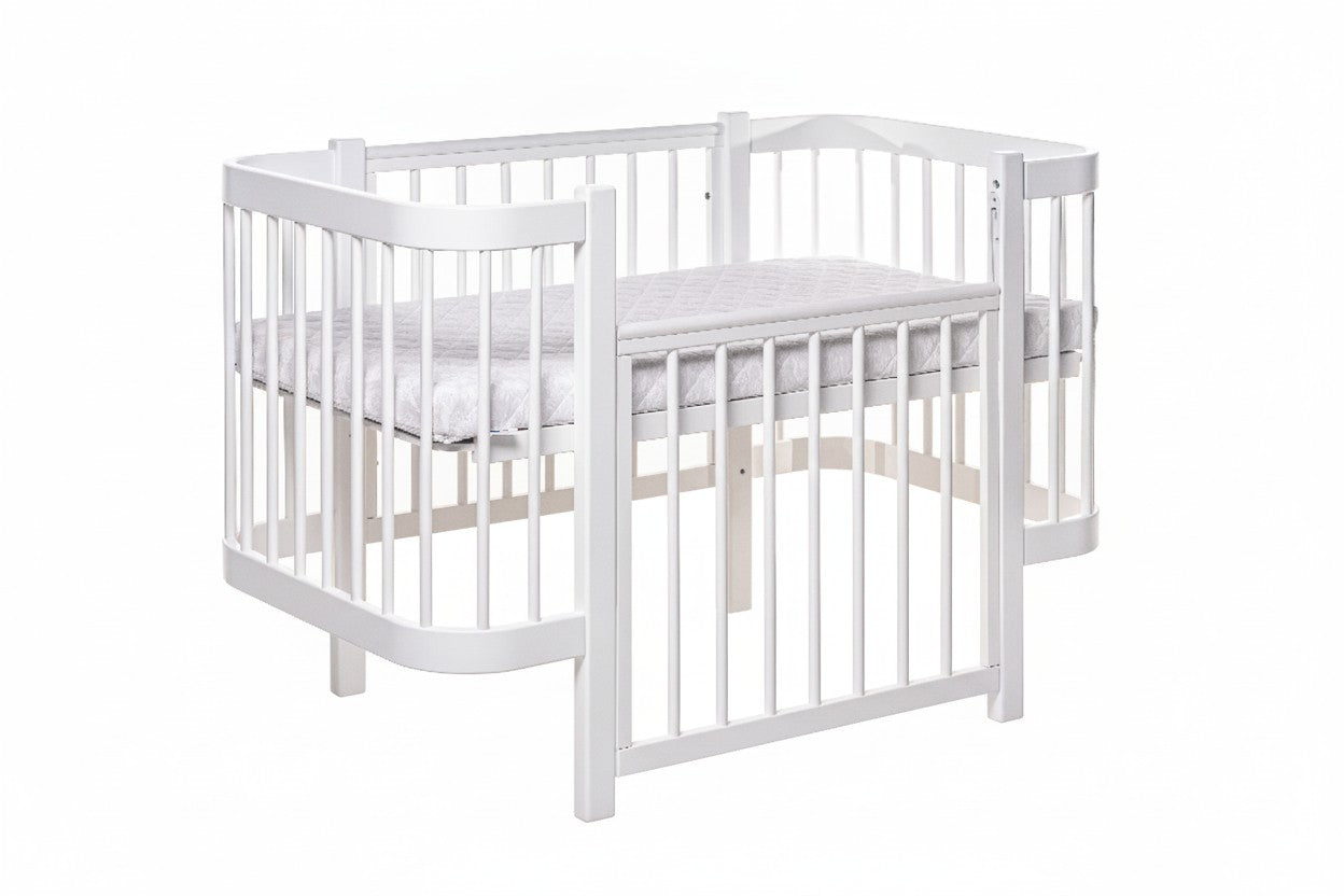 White KOTTO ELIN crib with one side panel removed showing bedside co-sleeping configuration