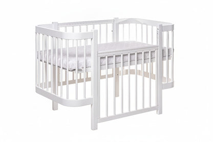 White KOTTO ELIN crib with one side panel removed showing bedside co-sleeping configuration