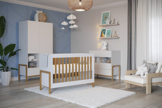 Scandinavian baby crib with oak legs and white panels in a modern nursery setting