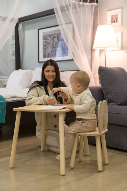 Child using wooden bunny table and chair set in bedroom for play and learning