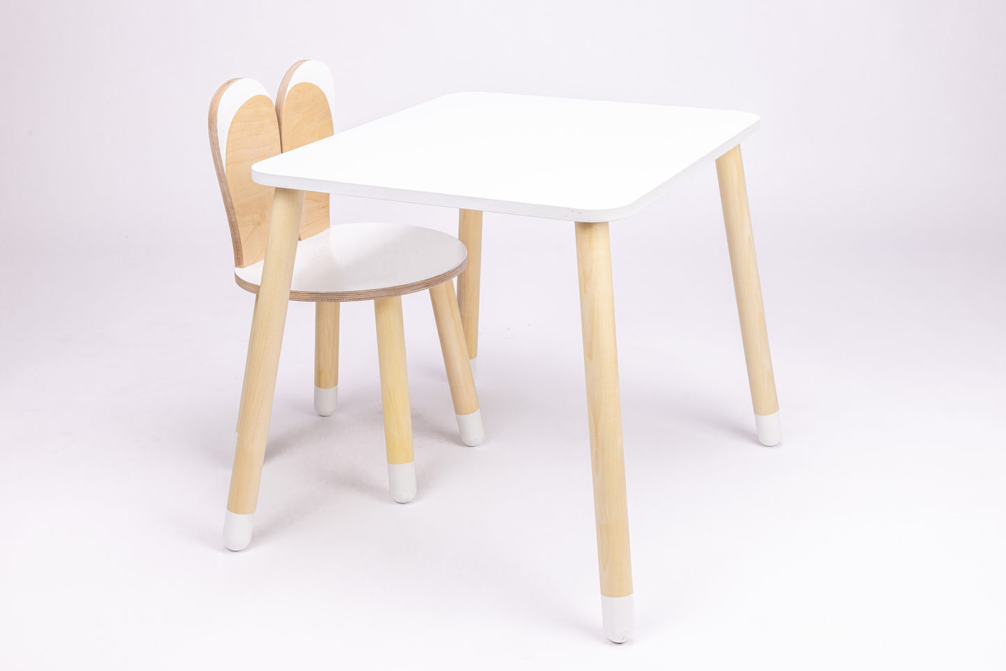 White wooden bunny table with rounded top and natural wood bunny-shaped chair, front view