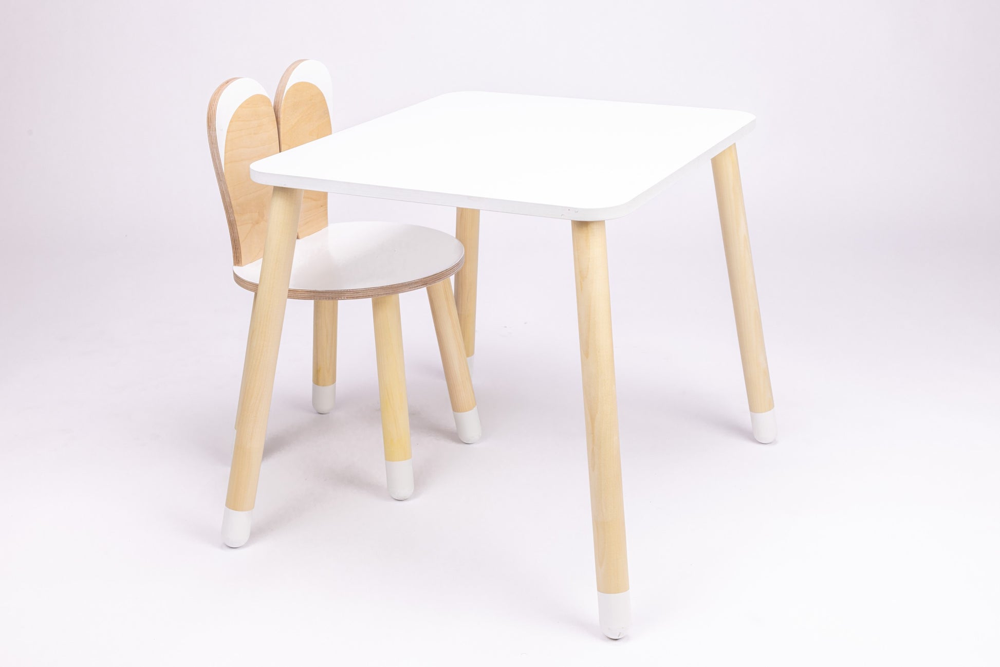 White wooden bunny table with rounded top and natural wood bunny-shaped chair, front view