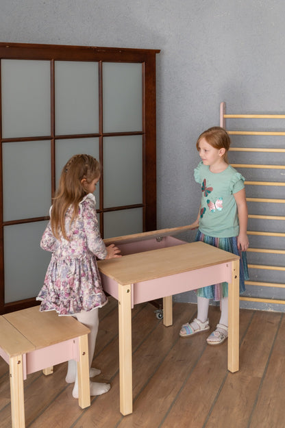 Two children using pink storage table with hinged top for play and study