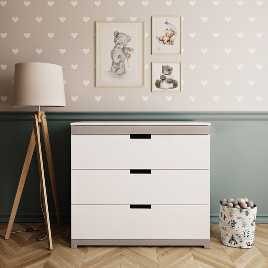 White Tomi chest of drawers with grey accents and black handles in nursery room setting