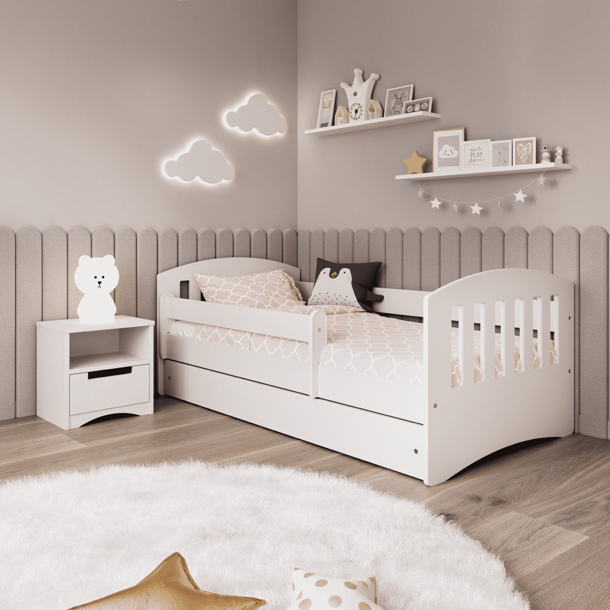 White kids bed with guardrail in styled nursery with wall decor and matching nightstand