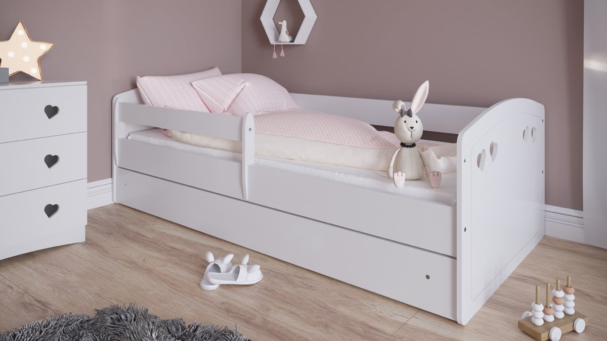 White Julia toddler bed with safety rails and storage drawer, side view with bedding