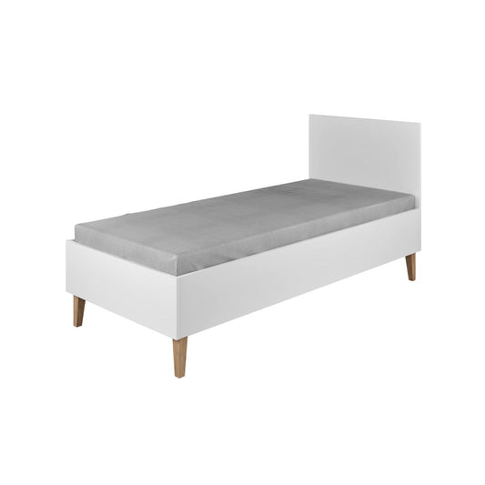 White Kubi children's bed with oak legs and headboard, angled view