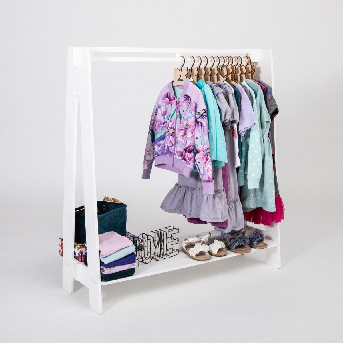 White birch plywood toddler clothing rack displaying colorful dresses and shoes in use