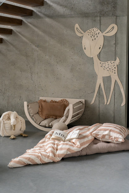 Birch plywood deer wall art displayed above nursery bed with striped bedding