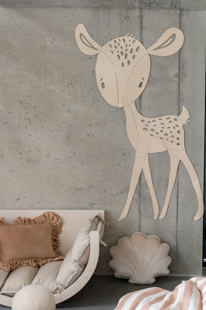 Birch plywood deer wall decoration with antlers displayed above white crib