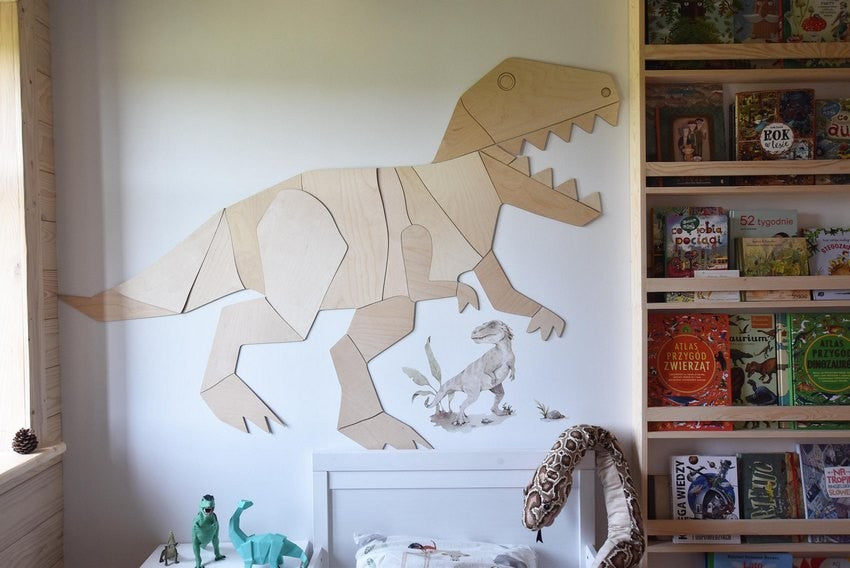 Assembled wooden dinosaur T-Rex wall art mounted on white bedroom wall above bookshelf