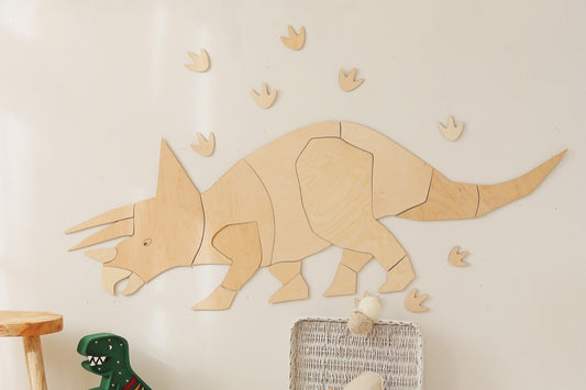 Wooden triceratops wall decoration with puzzle-style pieces and bonus footprints mounted on wall