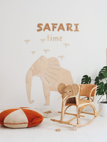 Safari-themed wooden elephant wall art with text and acacia trees above rocking chair