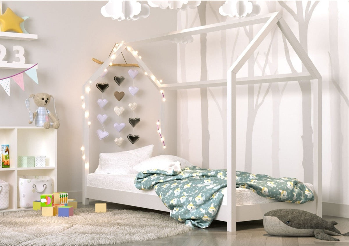 White pine house bed in children's bedroom with decorative heart garland and floral bedding