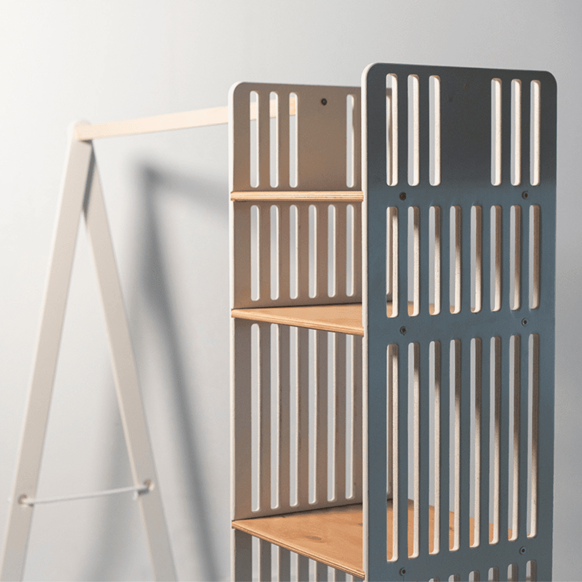 Charcoal gray and natural wood kids clothing rack displaying open shelf storage with vertical slatted panels