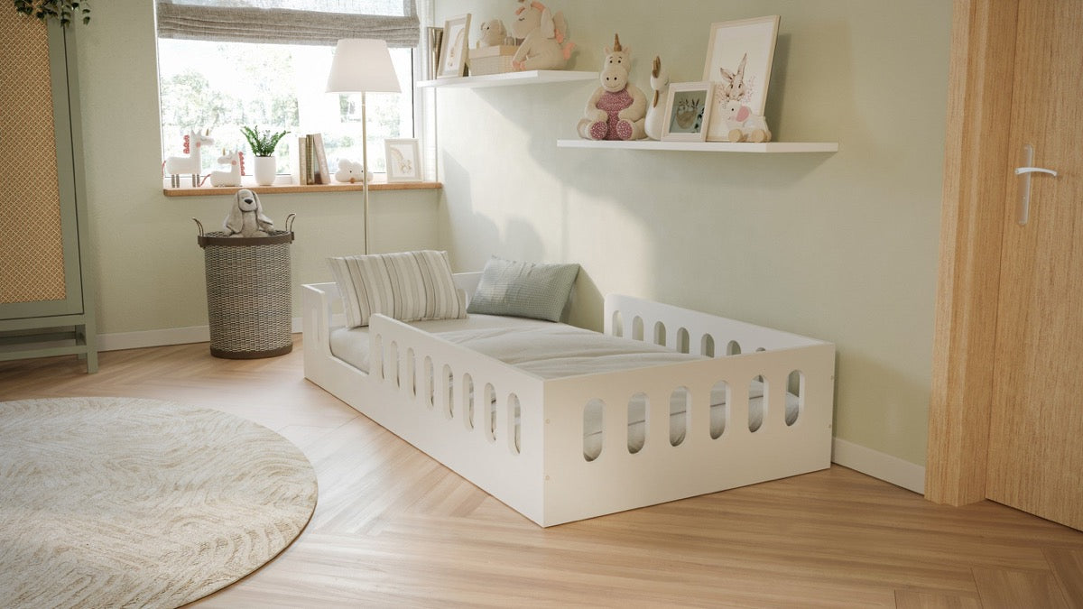 White Montessori floor bed in modern nursery with wooden flooring and natural decor