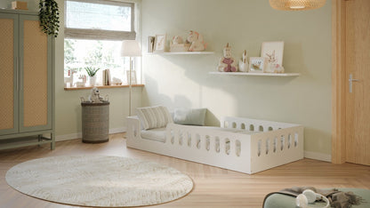 Space-saving white floor bed frame in styled children's bedroom with round rug