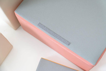 Textured surface detail of foam blocks showing soft material and pastel pink edge binding
