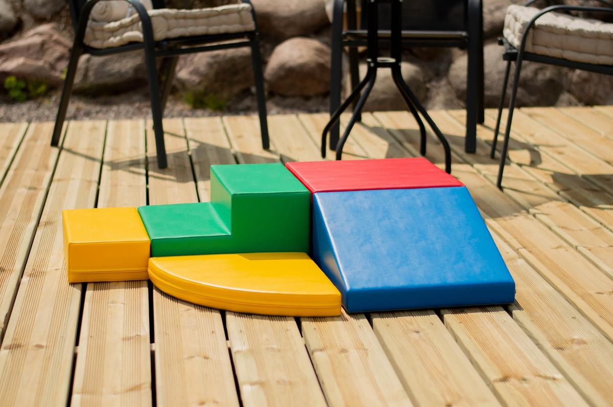 Five-piece multicolor foam corner climber set assembled on outdoor wooden patio