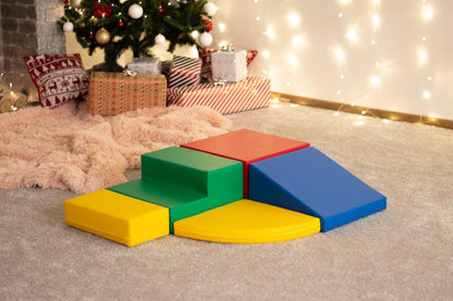 Multicolor foam climbing blocks set up indoors with holiday decorations in background