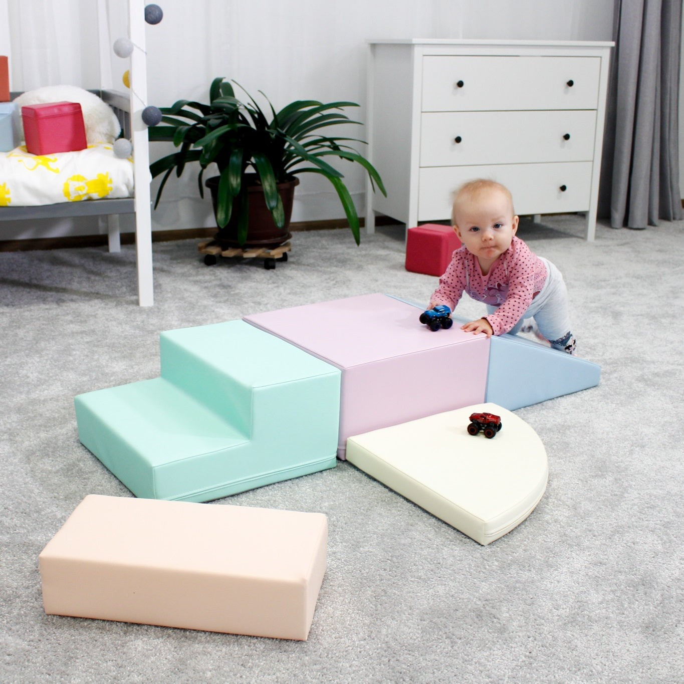 Child balancing on blue-gray pastel foam block while playing