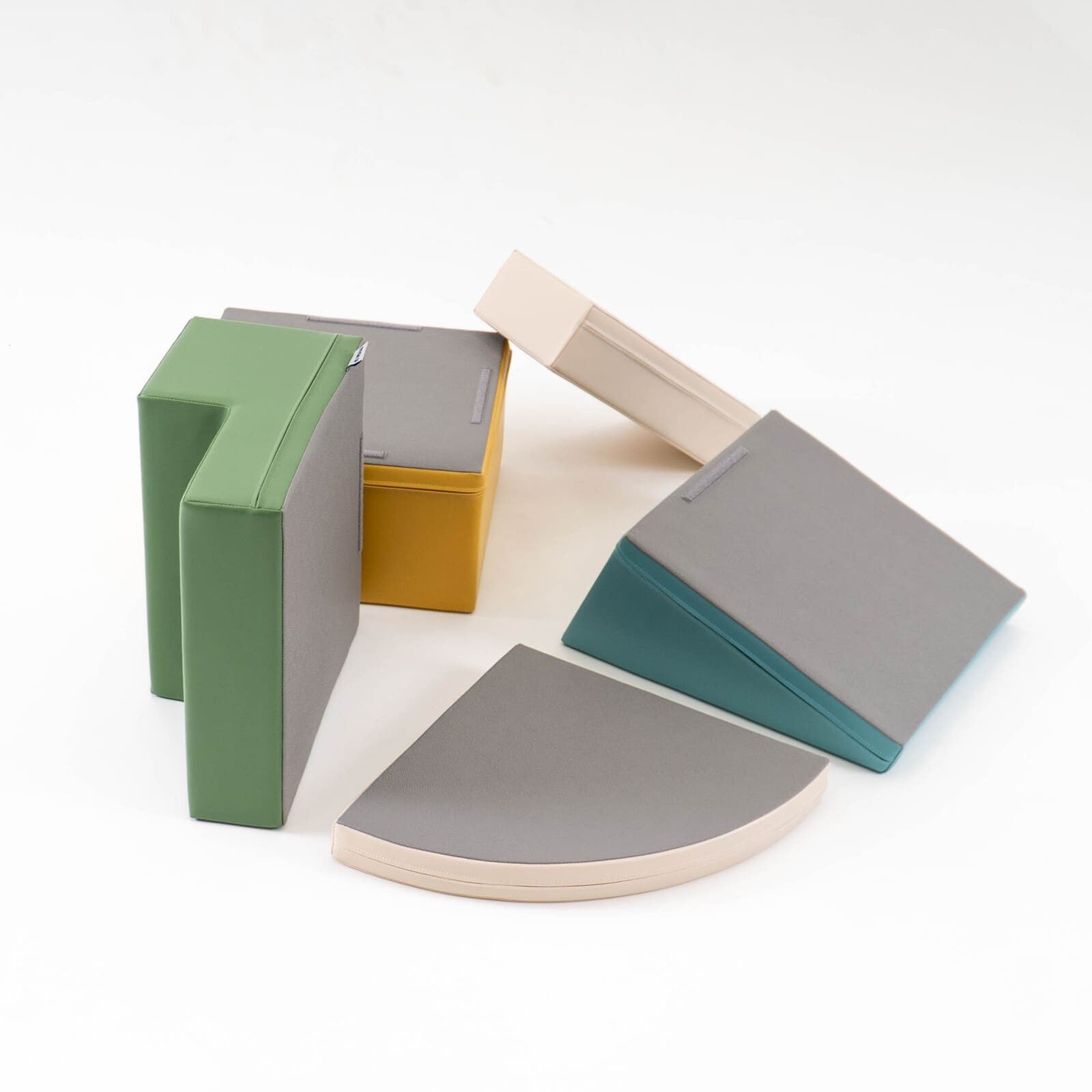 Disassembled view of foam block set showing individual turquoise, green, cream and gold pieces separated