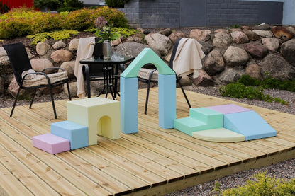 Outdoor view of light pastel foam blocks built into arch and ramp configuration on wooden platform