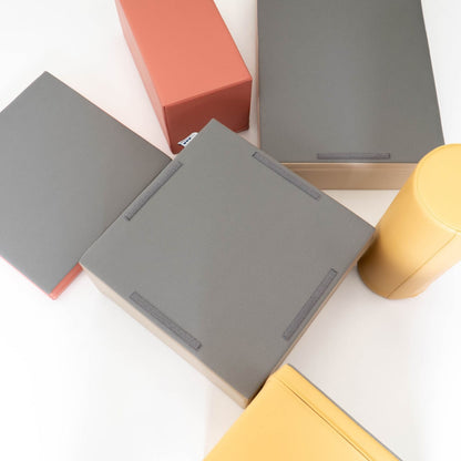 Overhead view of foam blocks showing non-skid bottom texture and zippers in pastel pink, gray, beige and yellow