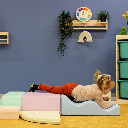 Two toddlers playing on assembled light pastel foam blocks in montessori-style setup