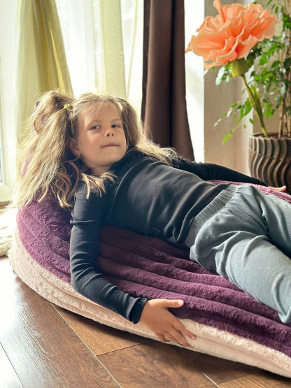 Child lounging in soft ribbed plush beanbag with mousse and berry color blocks