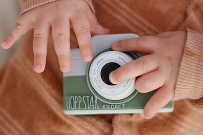 Mâini de copil pe aparatul foto verde Hoppstar Expert Laurel