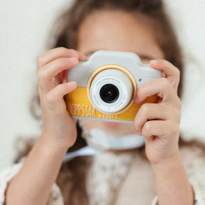 Fetiță fotografiază cu aparatul foto galben Hoppstar Expert Citron