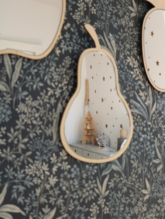 Pear-shaped wooden mirror with acrylic hanging on patterned nursery wall next to star decals