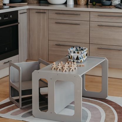 Gray Montessori weaning table and chair set in kitchen with wooden blocks and basket