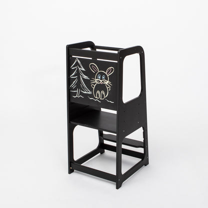Black kitchen tower with blackboard panel featuring chalk drawings of forest animals and tree