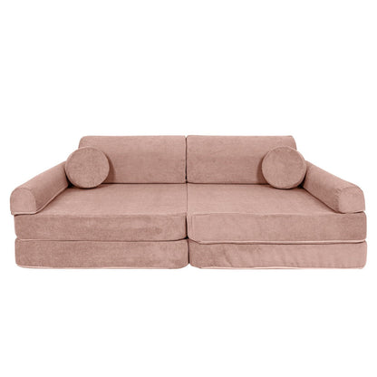Pink slimcord corduroy modular sofa in couch form with cylindrical arm supports