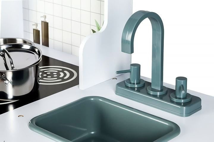 Close-up of turquoise movable faucet and dark green sink basin on play kitchen counter
